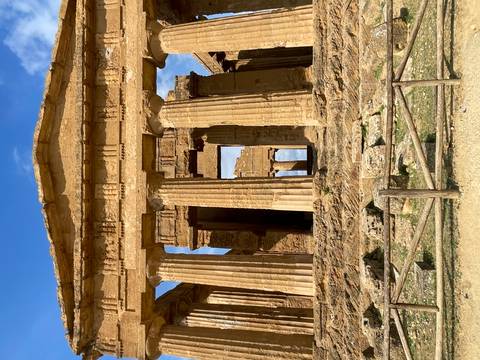 Well-preserved ancient Greek temple columns with blue sky backdrop at archaeological site.