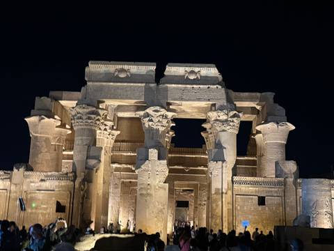 Night illumination highlights the columns and carvings of Kom Ombo Temple against a dark sky.