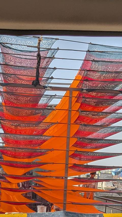 Colorful patterned fabric panels stretched across a metal frame forming a vibrant canopy overhead.