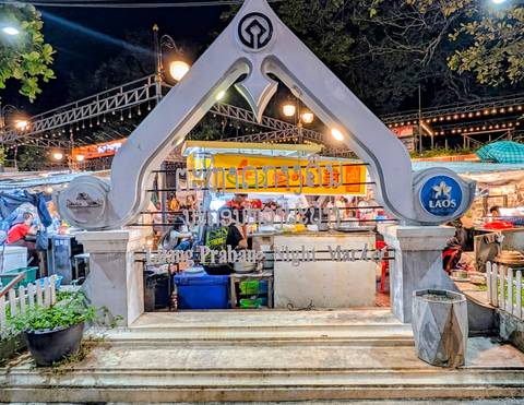 Entrance arch to the bustling Luang Prabang Night Market with vendors and bright lights