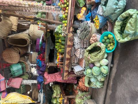 An assortment of fresh vegetables, eggs and spices displayed in a rustic market stall.