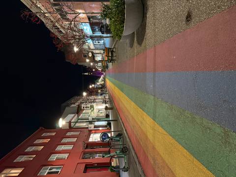 Rainbow-painted pedestrian street leading to Hallgrímskirkja at night.