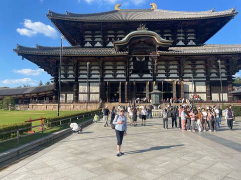 Front of Tōdai-ji temple with visitors gathered on the stone courtyard.