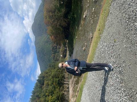 Traveler posing beside a mountain river in the traditional village of Shirakawa-go.