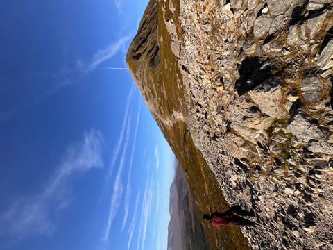 Rocky mountain trail leading up Croagh Patrick under deep blue sky with thin cloud streaks.