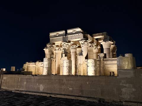 Kom Ombo Temple dramatically illuminated against the night sky, highlighting intricate columns.