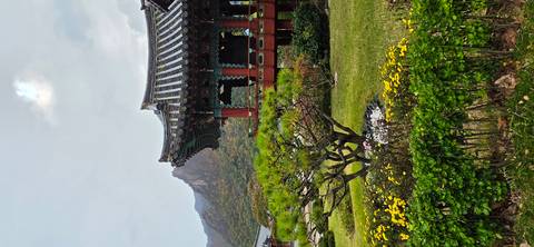Traditional wooden pavilion with tiled roof and mountain backdrop amid manicured gardens in Seoraksan National Park.