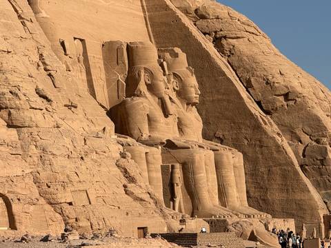 Colossal seated statues carved into the sandstone facade of Abu Simbel Temple
