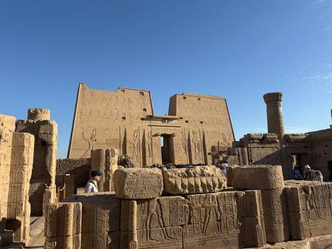 View of Edfu Temple pylons and hieroglyphic walls under clear blue sky