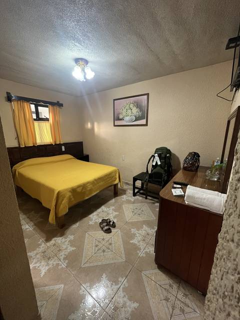 Tilted image of a hotel room with a yellow bedspread.