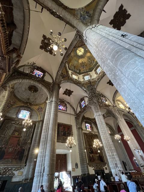 Tilted image of a cathedral's interior with ornate ceilings and chandeliers.