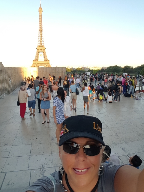 Crowd near the Eiffel Tower with a prominent monument.
