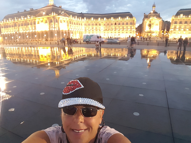 Selfie with a historic building lit up at night.