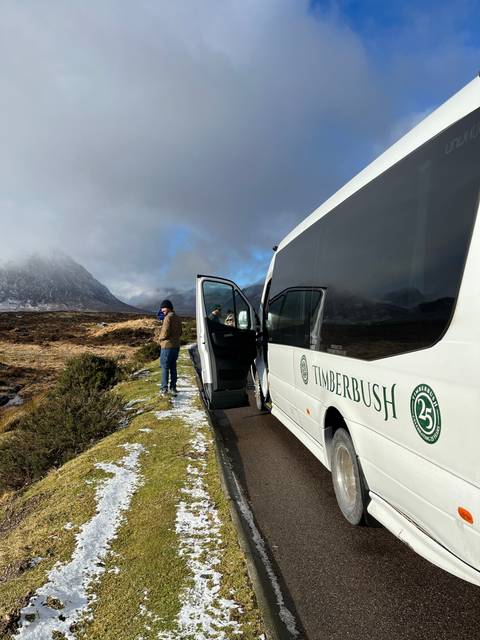 Bus with people in a snowy landscape.