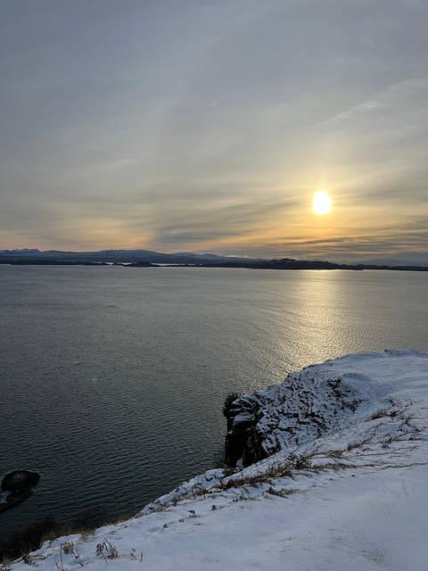 Snow-covered landscape with a view of the sea.