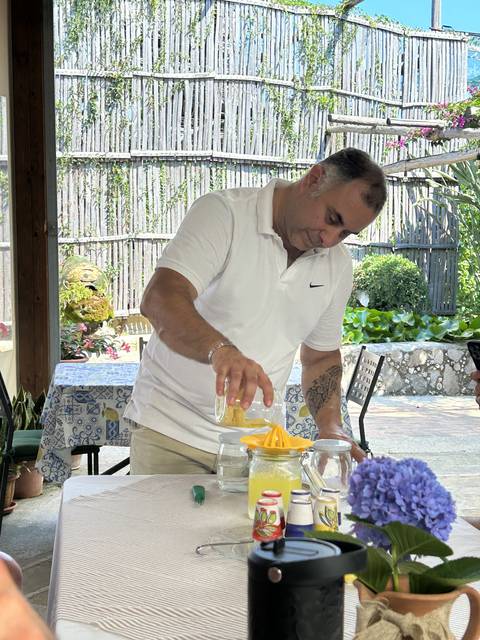 Man preparing beverages at a table outdoors.