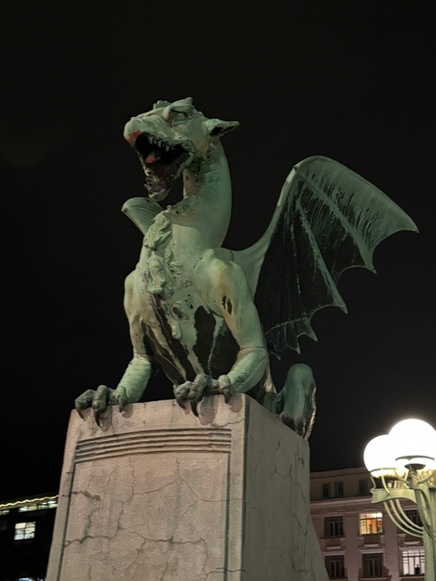 Statue of a dragon on a bridge, captured at night.