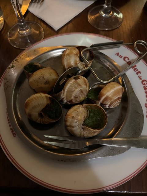 Escargots served on a plate with utensils.
