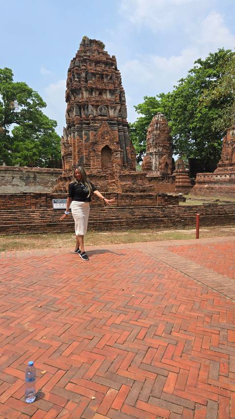 A woman posing in front of ancient temple structures.