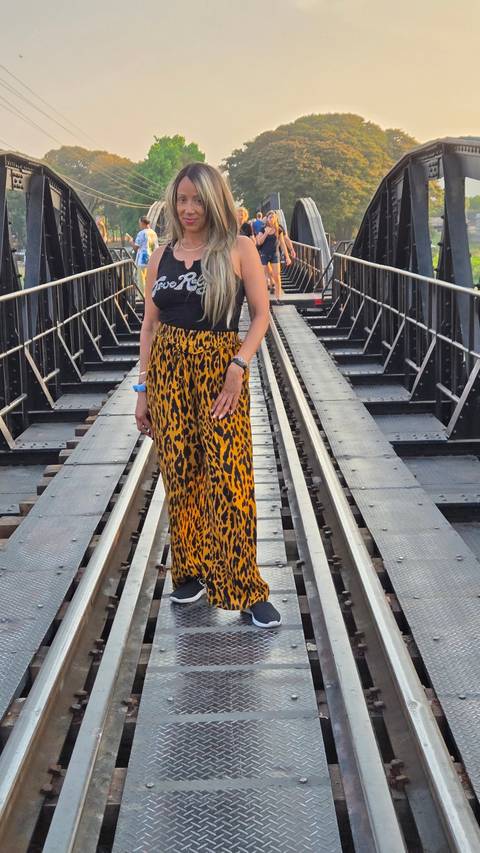 A woman standing on a bridge over a river.