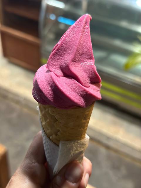 A close-up of a vibrant pink ice cream cone.