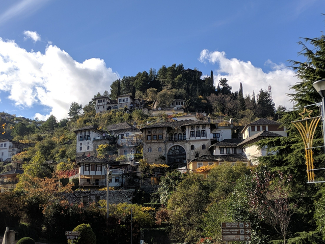 Traditional stone houses on a hillside under clear blue skies.