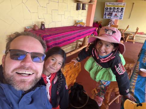 A man and children sitting inside a colorful interior.