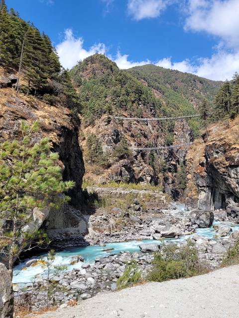 Steep gorge with a flowing river at its base.