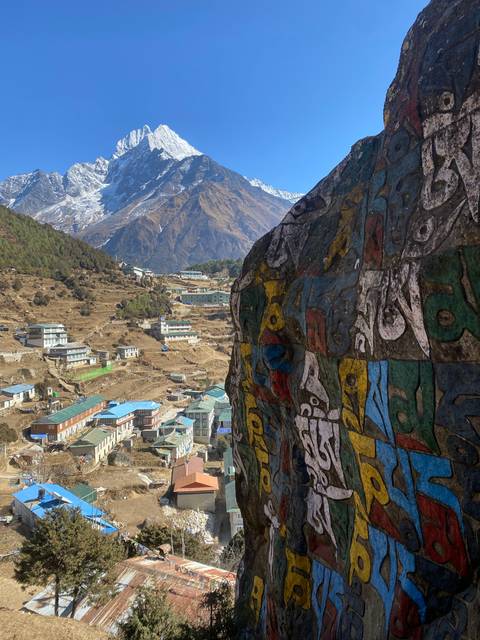 Colorful rock with snow-capped mountains in the background.