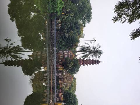 Pagoda reflected in a lake surrounded by trees.