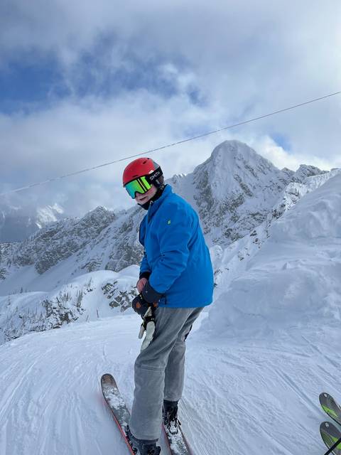 Person skiing down a snowy mountain slope.
