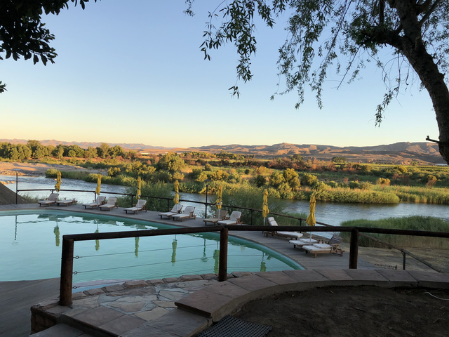 Scenic river view with a swimming pool in the foreground.