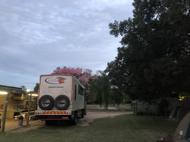Safari truck parked under a cloudy sky.