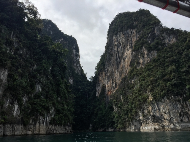Tall limestone cliffs with dense forest.