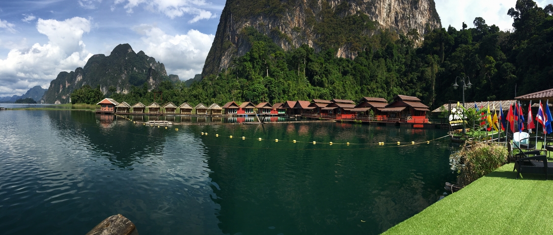 Floating bungalows on a calm lake with mountain views.