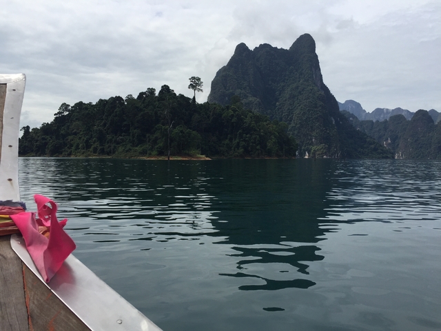 Boat bow pointing toward tall limestone cliffs.