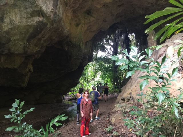 Tourists walking through a cave entrance.