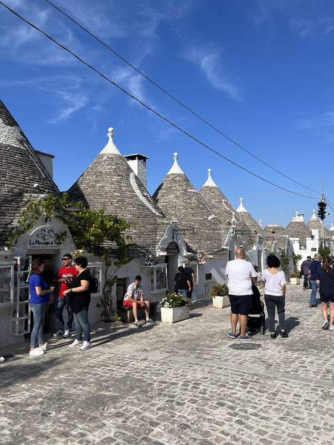 People visiting traditional trulli houses.