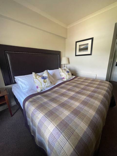 A bed with plaid bedding in a hotel room.