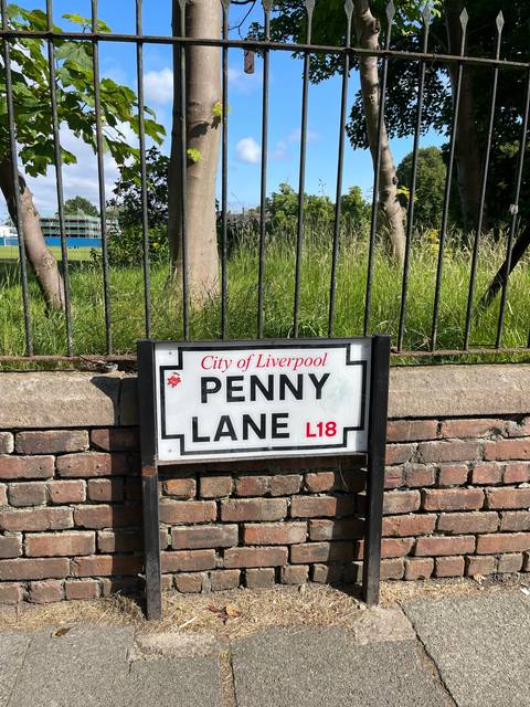 A street sign reading 'Penny Lane, City of Liverpool, L18'.
