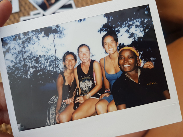 Polaroid image of a group sitting together and smiling.