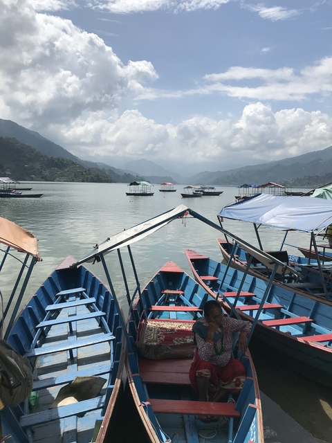 Colorful boats on a lake with mountains in the background.