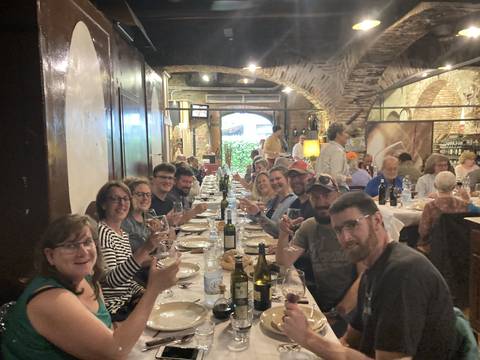 Group of people dining at a long table indoors.