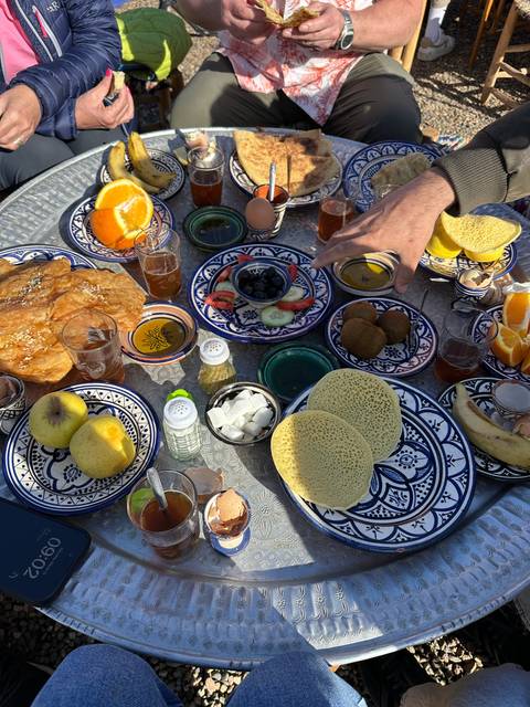 Table with plates of Moroccan food and drinks.