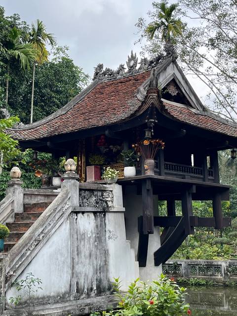 Traditional roof on a decorated temple with surrounding greenery.