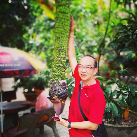 Man posing with a large tropical fruit.