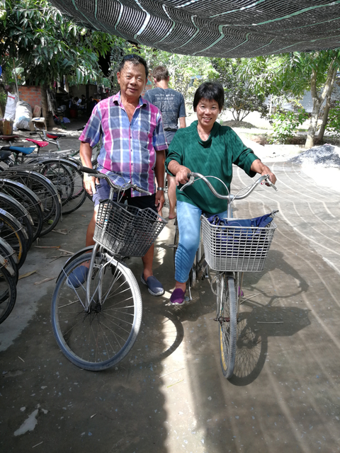 Two people posing with bicycles.