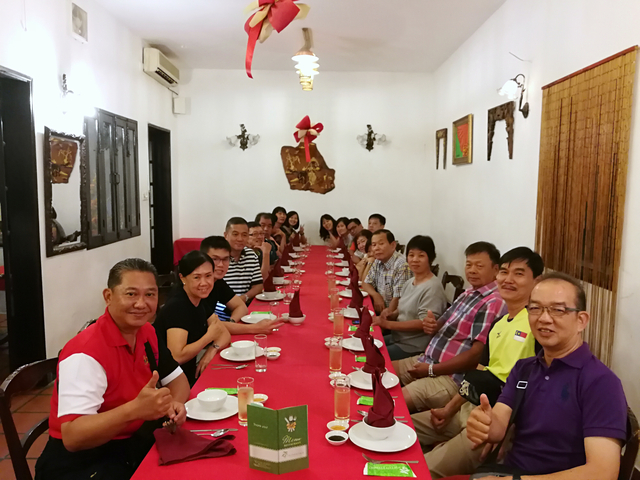 Large group of people dining together at a long table.