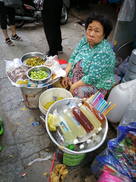 Food vendor selling various pickled items and drinks.