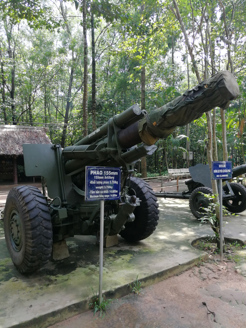 Old artillery piece displayed outdoors in a park.